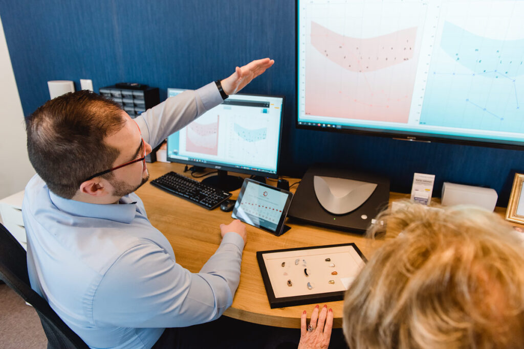 Analyse der Hörwerte durch den Hörakustiker mit Kundin am Beratungstisch.
