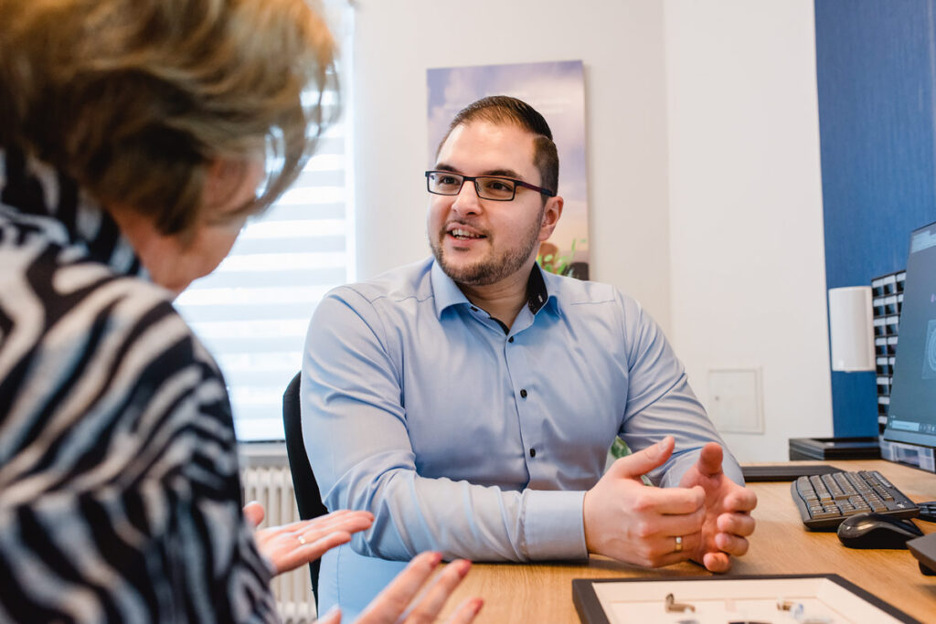 Hörakustiker im Gespräch mit Kundin bei individueller Beratung.